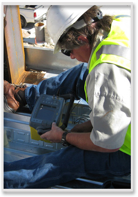 Technician performing calibration on ultrasonic instrument and preparing to test a field weld on a commercial building.